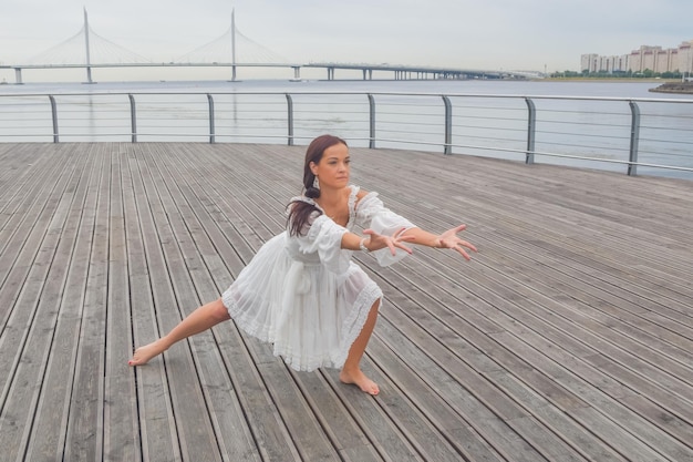 Sul lungomare una ragazza con un vestito bianco che balla