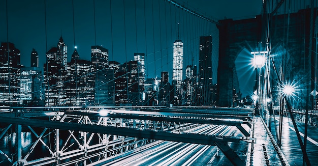 Sul ponte di Brooklyn di notte con traffico automobilistico, NY, USA.