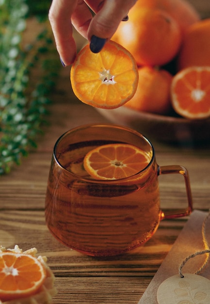 Sul tavolo c'è una tazza di tè vitaminico con mandarini