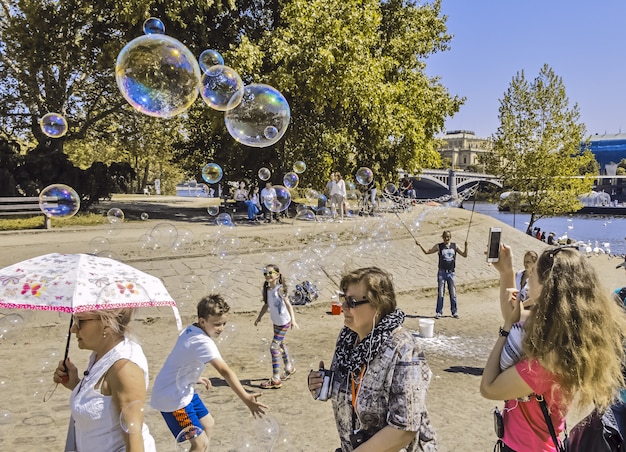 sull'argine del fiume Moldava l'uomo lancia le bolle per la gioia dei turisti praga ceca