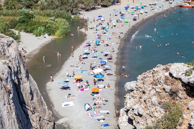 Sulla spiaggia sabbiosa di Preveli, sull'isola di Creta, in Grecia, si vedono persone che si godono le vacanze estive.