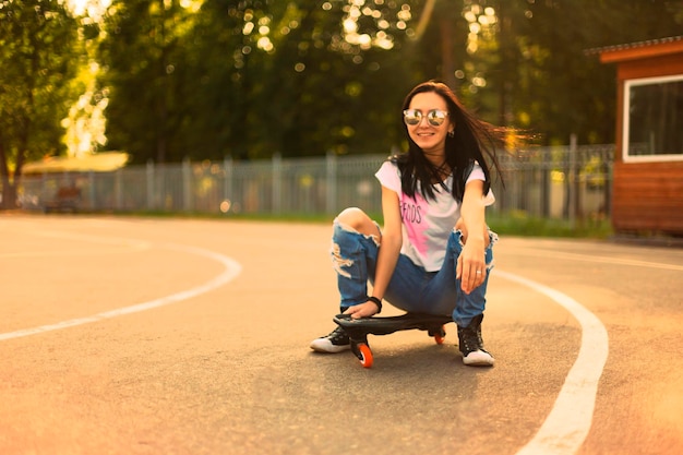 Summer la ragazza nel parco in sella a uno skateboard