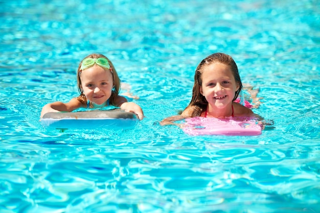 Summer Rocks Due bambine usano i gonfiabili della piscina mentre nuotano