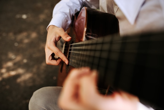 Suonando con la chitarra acustica all&#39;aperto. Macrofotografia.