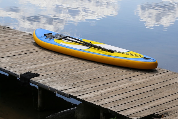 Sup board, stand up paddle board vicino al fiume sul molo