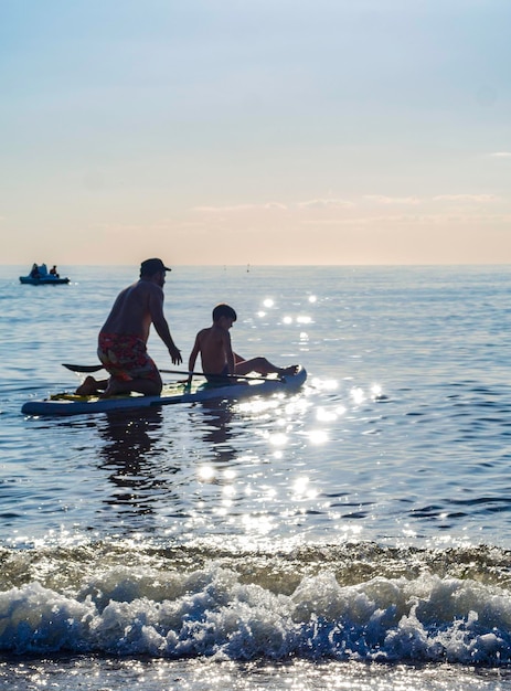 Sup surf training padre e sole nuotano in mare aperto su SAP surfing