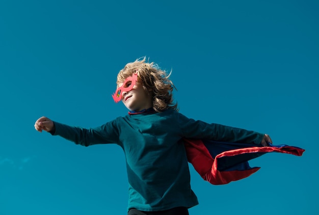 Super eroe bambino in un cappotto da supereroe rosso concetto di super eroe