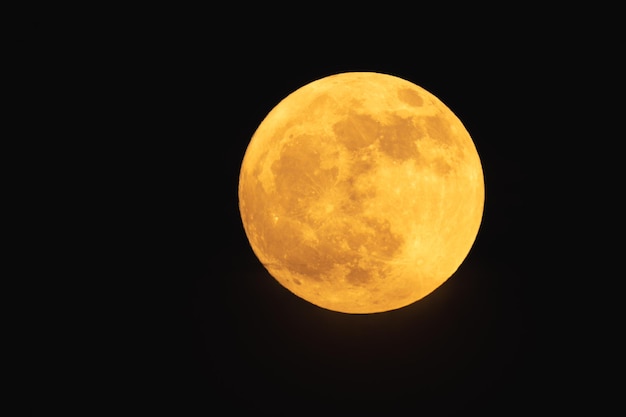 Super fragola luna rossastra luna piena in una notte di luna piena d'estate con nuvole avanti