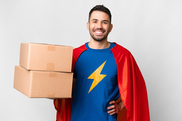 Super Hero consegna uomo caucasico su sfondo bianco isolato in posa con le braccia all'anca e sorridente