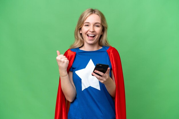 Super Hero donna inglese su sfondo isolato con il telefono in posizione di vittoria