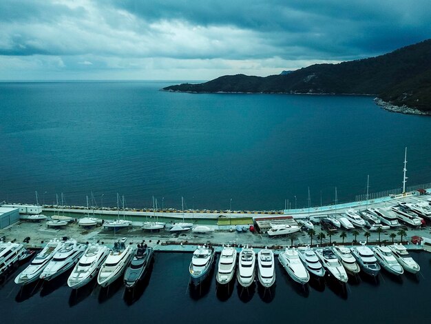 Super yacht di lusso ormeggiato nel marina vista aerea da drone Acqua di mare blu Porto yacht mediterraneo con barche a vela Concetto di yachting