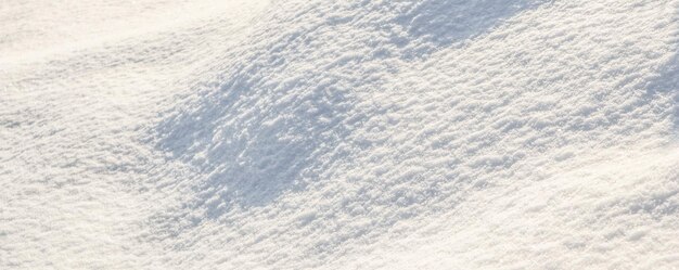 Superficie collinare ricoperta di neve fresca in giardino in una giornata di sole. Sfondo invernale naturale.