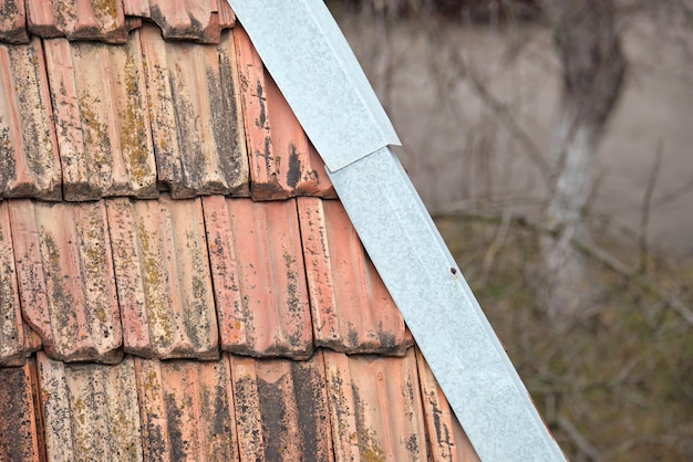 Superficie del primo piano di vecchie piastrelle di ceramica stagionate che coprono il tetto dell'edificio