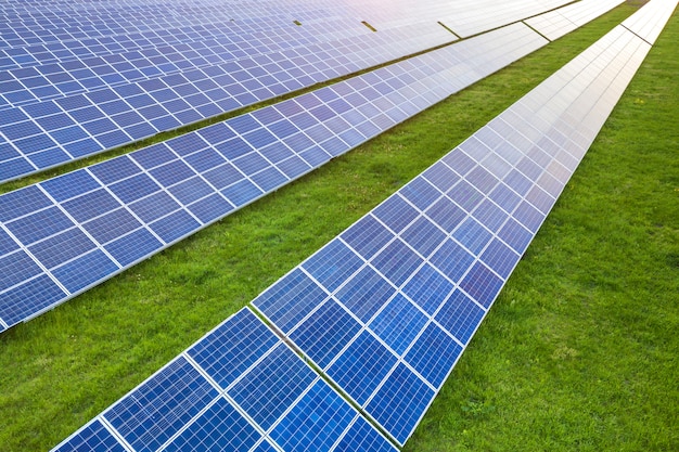 Superficie del sistema fotovoltaico solare dei pannelli fotovoltaici che produce energia pulita rinnovabile su erba verde.