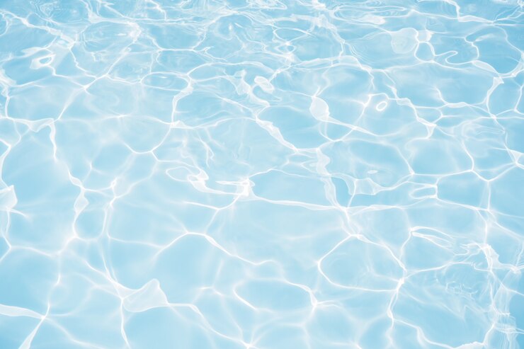 Superficie dell'acqua blu con le riflessioni luminose del sole nel fondo della piscina