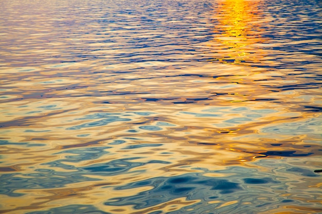 Superficie dell'acqua colorata reale al tramonto - sfondo naturale