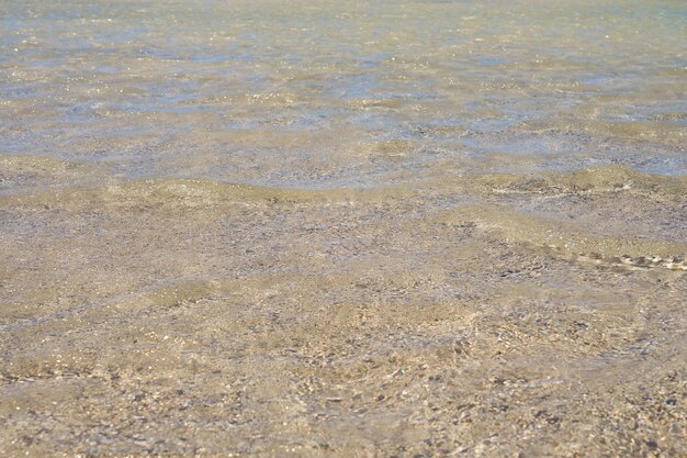 Superficie di acqua chiara sulla spiaggia sabbiosa tropicale in Creta Grecia.