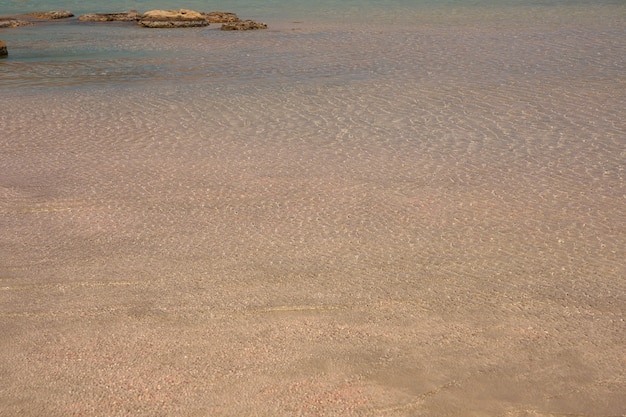 Superficie di acqua chiara sulla spiaggia sabbiosa tropicale in Creta Grecia.