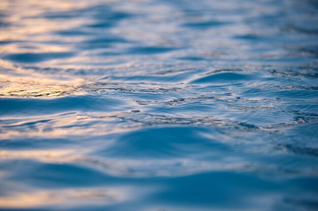 Superficie di vista sul mare del primo piano dell'acqua di mare blu con piccole onde ondulate.