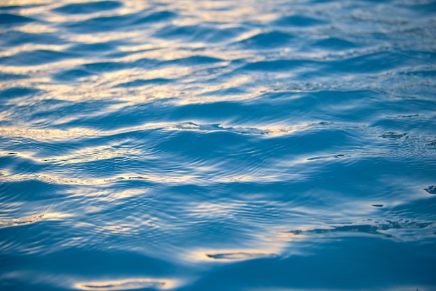 Superficie di vista sul mare del primo piano dell'acqua di mare blu con piccole onde ondulate.