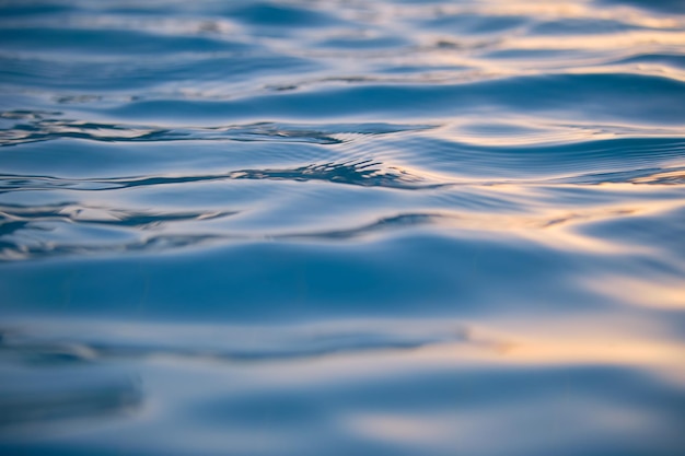 Superficie di vista sul mare del primo piano dell'acqua di mare blu con piccole onde ondulate.