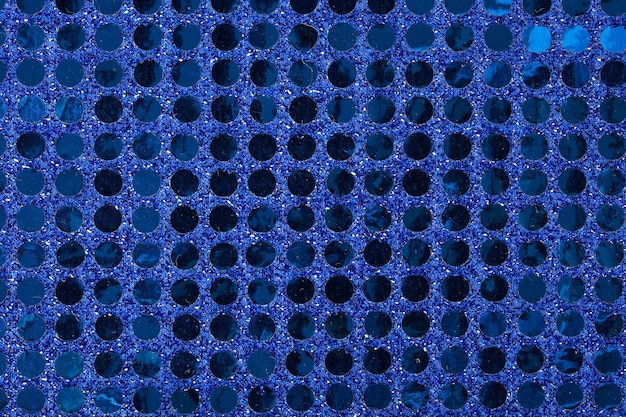 Superficie in tessuto brillante blu scuro ricoperta da paillettes. Sfondo