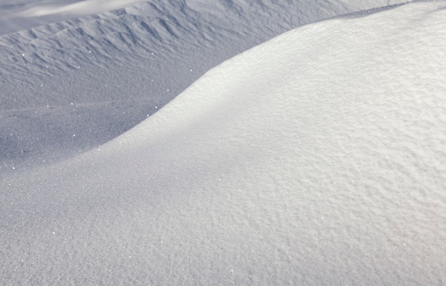 Superficie ondulata e collinare di cumuli di neve profonda nella stagione invernale, bellissima natura in una gelida mattina