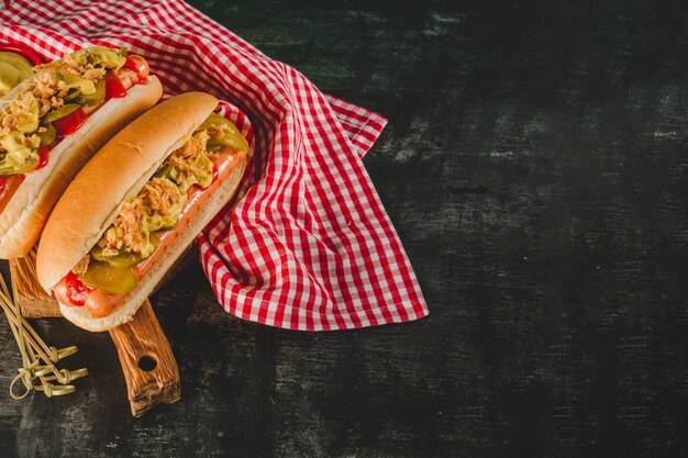 superficie scura con tovaglia due deliziosi hot dog