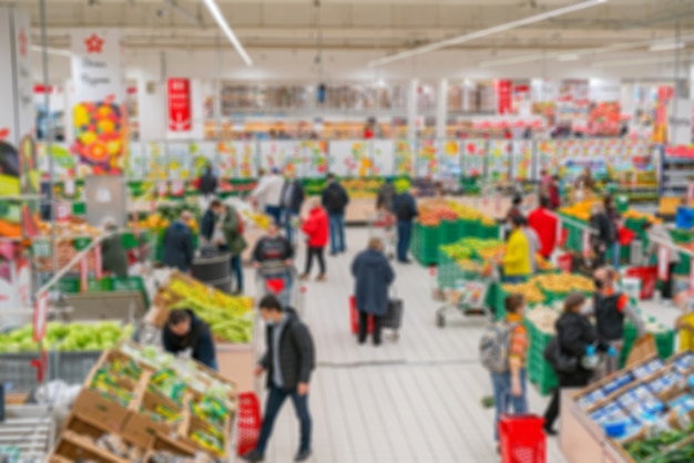 Supermercato sfocato. Vendita di merci in un negozio al dettaglio. Sfondo sfocato di acquirenti in un negozio.