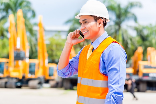 Supervisore asiatico che telefona sul cantiere