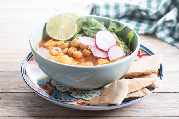 Suppa tradizionale messicana di pozole rosso su un tavolo di legno