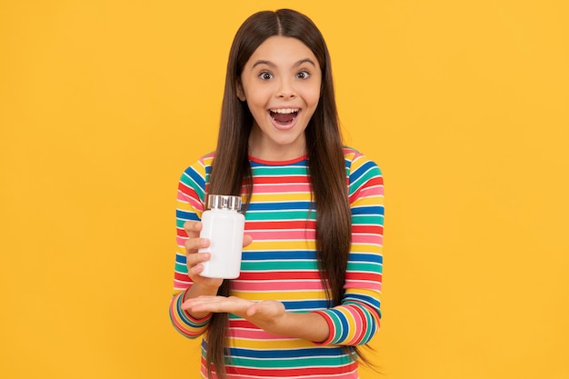 Supplemento di cibo. ragazza con prodotti pillola naturali. presentando il prodotto vitaminico. bambino sorpreso con il barattolo della pillola. tablet per bambini. ragazza tenere multivitaminico. uno stile di vita sano. salute dell'infanzia.