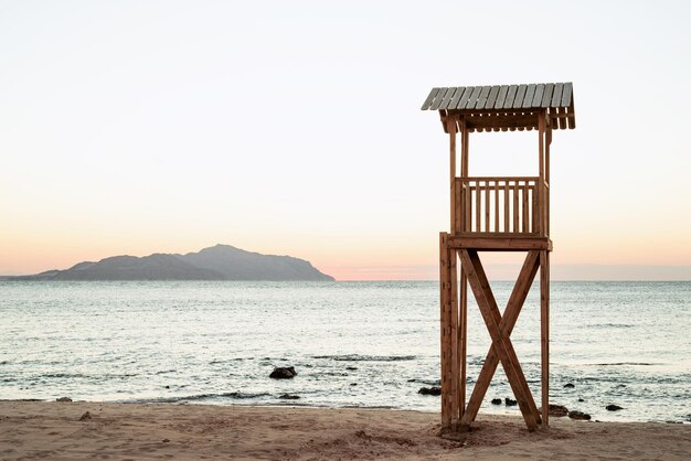 Supporto bagnino in legno di sicurezza bagnino spiaggia su spiaggia sabbiosa all'alba