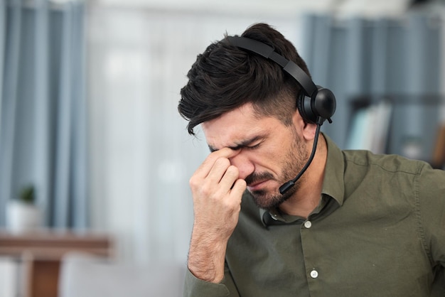 Supporto tecnico di telemarketing e uomo con mal di testa burnout e straordinari con stress, dolore e tensione Impiegato e consulente di sesso maschile con un problema di salute di emicrania e agente con affaticamento