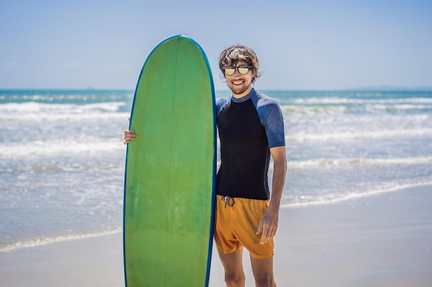 Surfista che tiene una tavola da surf sulla spiaggia