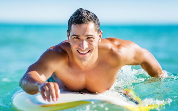 Surfista dell'onda estiva del surfista di nuoto in spiaggia