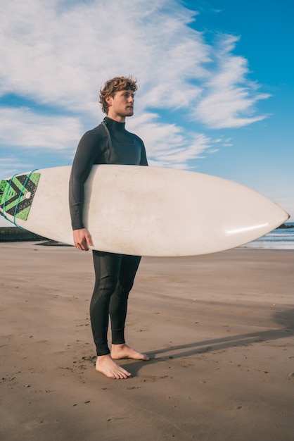 Surfista in piedi nell'oceano con la sua tavola da surf.