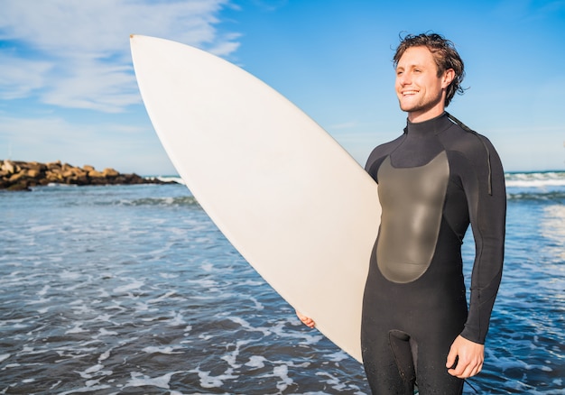 Surfista in piedi nell'oceano con la sua tavola da surf.