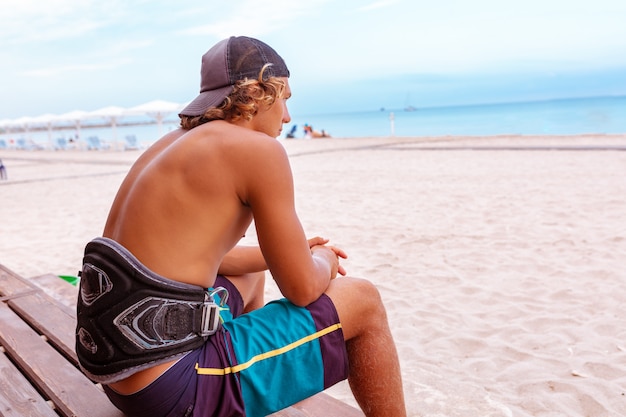 surfista seduto su una terrazza sulla spiaggia