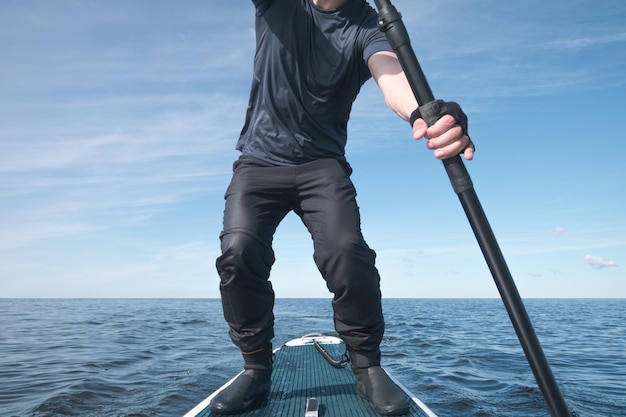 Surfista su una tavola da paddle in alto mare