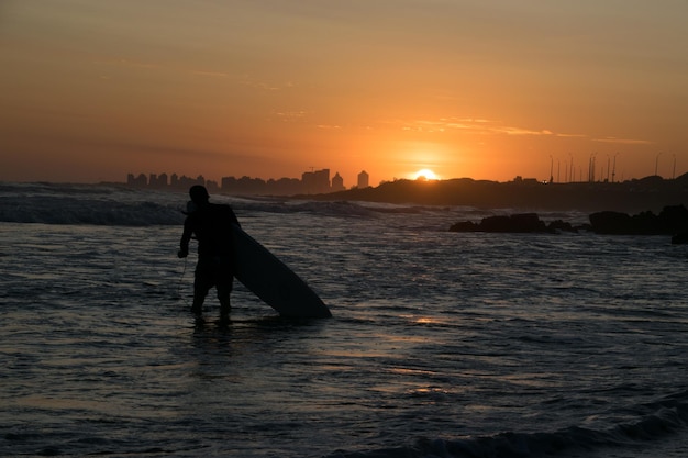 Surfisti in spiaggia durante il tramonto