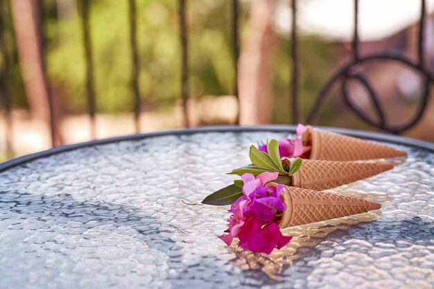 Surreali fiori di bouganville rosa brillante in un cono gelato Vacanze estive sfondo