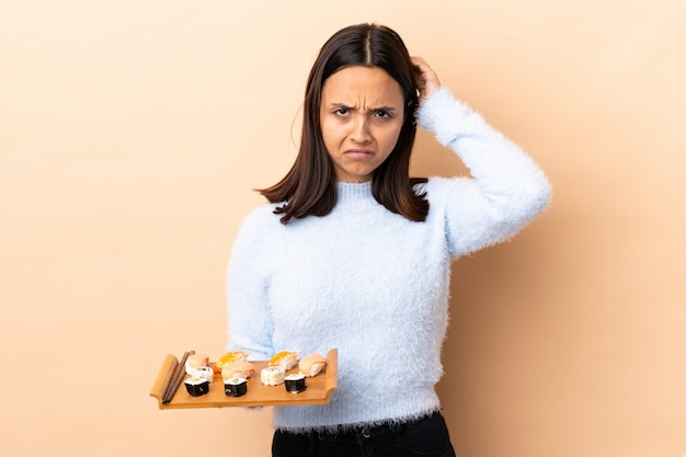 Sushi castani della tenuta della donna della giovane corsa mista