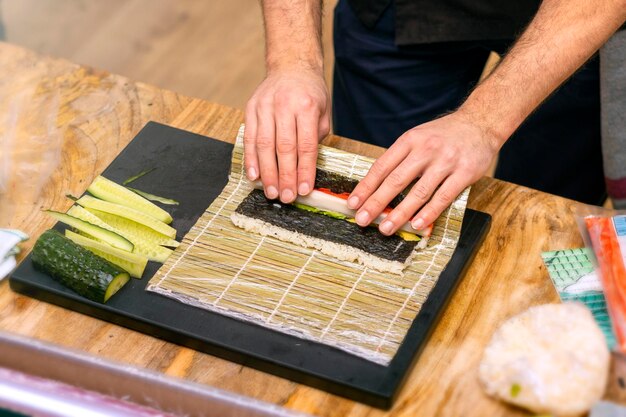 Sushi Chef Primo piano delle mani dello chef che preparano cibo giapponese Chef giapponese che fa il sushi al ristorante