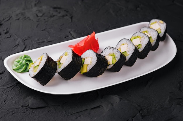 Sushi con formaggio feta e avocado su piatto bianco