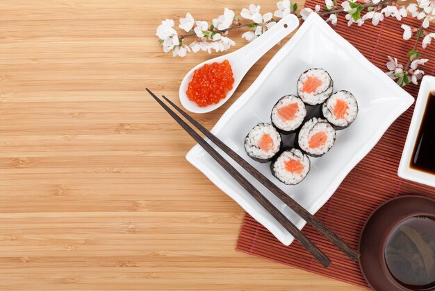 Sushi di caviale rosso con ramo di sakura e bacchette