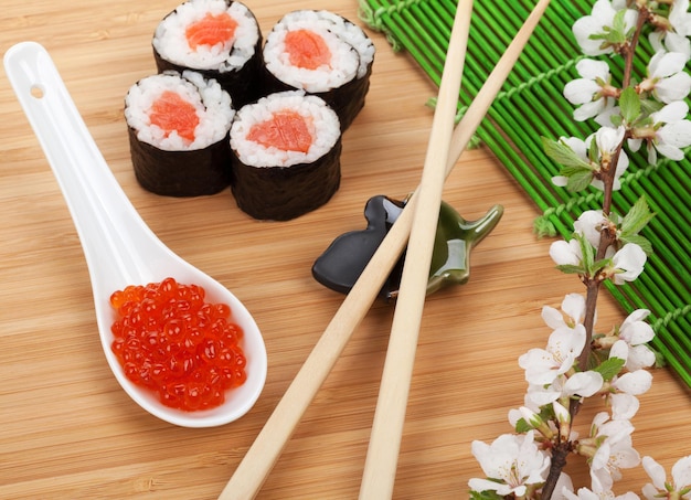 Sushi di caviale rosso con ramo di sakura e bacchette