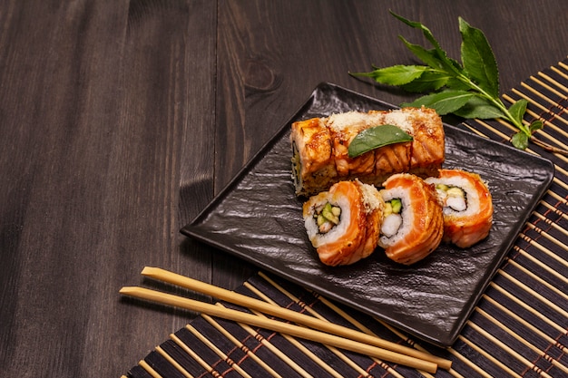 Sushi di gamberi tigre alla griglia. Rotolo giapponese o coreano con diversi ingredienti freschi. Sfondo nero alla moda