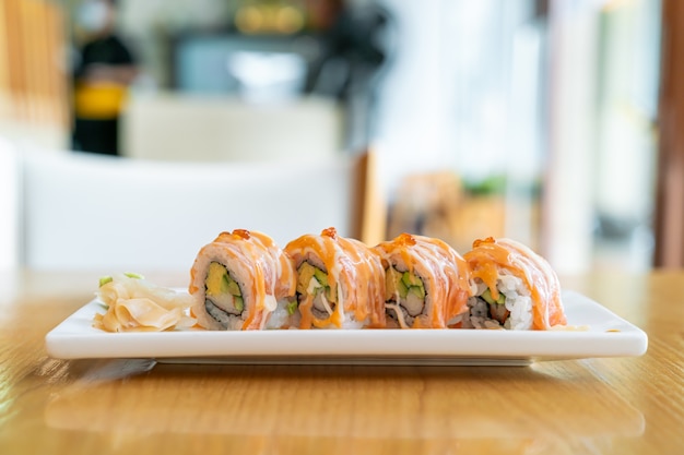 Sushi di rotolo di salmone con salsa in cima