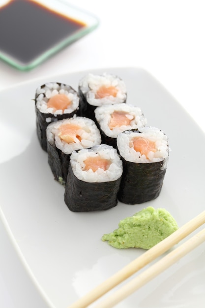 Sushi di salmone Maki con bacchette e salsa di soia in bianco